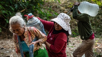 Warga mengangkut galon berisi air yang diambil dari belik di dasar sungai yang mengering di Dusun Ngedat, Desa Ketro, Grobogan, Jawa Tengah, Kamis (13/8/2026). [ANTARA FOTO/Aprillio Akbar/kye]