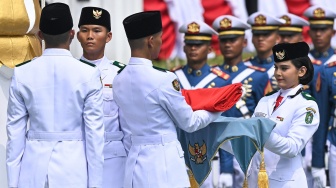 Anggota Pasukan Pengibar Bendera Pusaka (Paskibraka) Celina Olivia Apriani Theo (kanan) menyerahkan bendera Merah Putih kepada rekannya untuk dikibarkan pada Upacara Peringatan Detik-Detik Proklamasi Kemerdekaan Ke-81 Republik Indonesia di Istana Merdeka, Jakarta, Senin (17/8/2026). [ANTARA FOTO/Bayu Pratama S/app/wsj]
