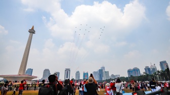 Warga melihat sejumlah pesawat jet tempur TNI AU yang terdiri dari F-16, Rafale dan Sukhoi membentuk formasi 81 saat terbang usai Upacara Peringatan Detik-Detik Proklamasi Kemerdekaan ke-81 Republik Indonesia di Monumen Nasional (Monas), Jakarta, Senin (17/8/2026). [Suara.com/Alfian Winanto]