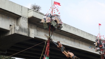 Peserta mengikuti lomba memanjat pohon pinang di Semarak Kalimalang 2026 di Jakarta, Senin (17/8/2026). [Suara.com/Novi]
