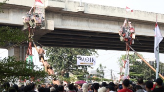 Peserta mengikuti lomba memanjat pohon pinang di Semarak Kalimalang 2026 di Jakarta, Senin (17/8/2026). [Suara.com/Novi]
