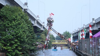 Peserta mengikuti lomba memanjat pohon pinang di Semarak Kalimalang 2026 di Jakarta, Senin (17/8/2026). [Suara.com/Novi]
