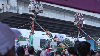 Peserta mengikuti lomba memanjat pohon pinang di Semarak Kalimalang 2026 di Jakarta, Senin (17/8/2026). [Suara.com/Novi]
