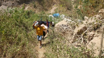 Sejumlah warga membawa bantuan menyusuri jalanan berbatu dari posko bantuan Desa Rokirole ke Desa Nitunglea, Pulau Palue, Kabupaten Sikka, NTT, Rabu (19/8/2026). [ANTARA FOTO/Mega Tokan/app/nym]
