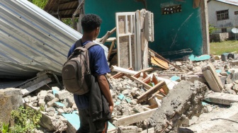 Warga melintas di samping bangunan rumah yang roboh akibat gempa bumi magnitudo 7,7 di Pulau Palue, Kabupaten Sikka, NTT, Rabu (19/8/2026). [ANTARA FOTO/Mega Tokan/app/nym]