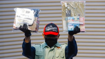 Petugas menunjukan barang bukti berupa uang tunai dari hasil Operasi Tangkap Tangan (OTT) saat konferensi pers terkait kasus korupsi Penerimaan Mahasiswa Baru di Universitas Jenderal Soedirman (Unsoed) Purwokerto di Gedung Merah Putih KPK, Jakarta, Jumat (21/8/2026). [Suara.com/Alfian Winanto]