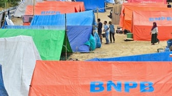 Pengungsi korban gempa bumi Nusa Tenggara Timur (NTT) berjalan di dekat tenda posko pengungsian di Lapangan Barangkolong, Reo, Kabupaten Manggarai, NTT, Kamis (20/8/2026). [ANTARA FOTO/Fikri Yusuf/nym]