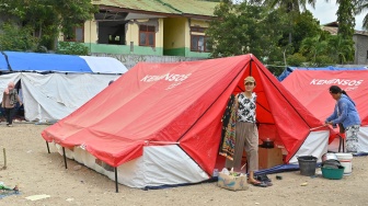 Pengungsi korban gempa bumi Nusa Tenggara Timur (NTT) berjalan di dekat tenda posko pengungsian Lapangan Barangkolong, Reo, Kabupaten Manggarai, NTT, Kamis (20/8/2026). [ANTARA FOTO/Fikri Yusuf/nym]
