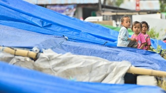 Tiga anak bermain di posko pengungsian Lapangan Barangkolong, Reo, Kabupaten Manggarai, NTT, Kamis (20/8/2026). [ANTARA FOTO/Fikri Yusuf/nym]