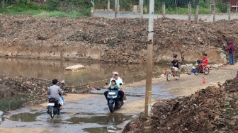 Pengendara melintasi akses jalan penghubung Kecamatan Cipayung dan Pasir Putih Sawangan yang sempat terendam selama empat tahun di Kampung Bulak Barat, Cipayung, Kota Depok, Jawa Barat, Jumat (21/8/2026). [ANTARA FOTO/Yulius Satria Wijaya/foc]
