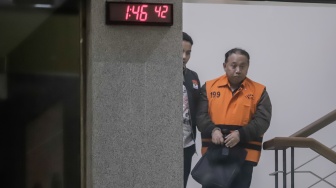 Rektor Universitas Jenderal Soedirman (Unsoed)  bersama tersangka lainnya berjalan menuju mobil tahanan usai menjalani pemeriksaan pasca terjaring operasi tangkap tangan (OTT) di Gedung KPK, Jakarta, Sabtu (22/8/2026) dini hari. [Suara.com/Alfian Winanto]