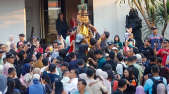Sejumlah warga merayah gunungan berisi sayur-sayuran saat prosesi Grebeg Maulud di Taman Mini Indonesia Indah, Jakarta, Selasa (25/8/2026).  [Suara.com/Alfian Winanto]