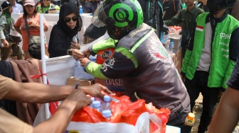 Pengemudi ojek online (ojol) membantu memindahkan logistik di depan Gedung DPR RI, Jakarta, Rabu (26/8/2026). [Suara.com/Alfian Winanto]

