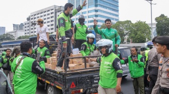 Pengemudi ojek online (ojol) membantu memindahkan logistik di depan Gedung DPR RI, Jakarta, Rabu (26/8/2026). [Suara.com/Alfian Winanto]
