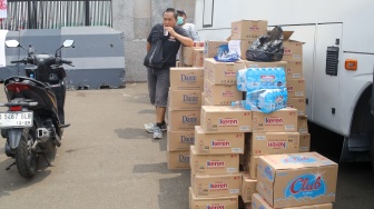 Pengemudi ojek online (ojol) membantu memindahkan logistik di depan Gedung DPR RI, Jakarta, Rabu (26/8/2026). [Suara.com/Alfian Winanto]
