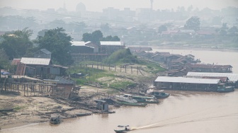 Sebuah perahu melintas di Sungai Kahayan yang diselimuti asap dampak kebakaran hutan dan lahan di Palangka Raya, Kalimantan Tengah, Jumat (28/8/2026). [ANTARA FOTO/Auliya Rahman/nym]
