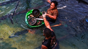 Warga mengumpulkan benda-benda berharga di antara puing-puing pascakebakaran di perkampungan Dok V, Mandala di Distrik Jayapura Utara, Kota Jayapura, Papua, Selasa (1/9/2026). [ANTARA FOTO/Gusti Tanati/app/YU]