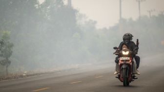 Pengendara sepeda motor melintas di Jalan Gubernur Syarkawi yang tertutup kabut asap akibat kebakaran hutan dan lahan (karhutla) di Kabupaten Banjar, Kalimantan Selatan, Rabu (2/9/2026). [ANTARA FOTO/Bayu Pratama S/nym]