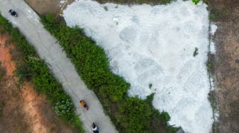 Foto udara pengendara motor melintas di dekat lokasi yang diduga tercemar limbah Bahan Berbahaya dan Beracun (B3) Potasium-40 di Kampung Bayur, Desa Nambo Udik, Kabupaten Serang, Banten, Kamis (3/9/2026). [ANTARA FOTO/Muhammad Bagus Khoirunas/wsj]