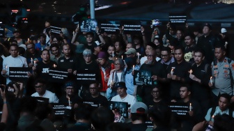 Sejumlah anggota Pewarta Foto Indonesia (PFI) dan jurnalis menggelar doa bersama di Bundaran HI, Jakarta, Jumat (11/9/2026). [Suara.com/Alfian Winanto]