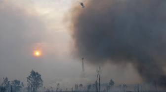 Helikopter Black Hawk VH-UHG milik BNPB melakukan pemadaman kebakaran lahan dari udara (water boombing) di Desa Rambutan, Kecamatan Indralaya Utara, Kabupaten Ogan Ilir (OI), Sumatera Selatan, Sabtu (12/9/2026). [ANTARA FOTO/Nova Wahyudi/tom]