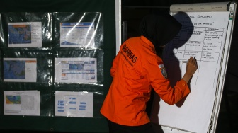 Personel Basarnas menuliskan jurnal komunikasi kapal-kapal yang dikerahkan pada operasi pencarian jurnalis dan awak kapal yang hilang kontak di Posko SAR Dermaga Marina Carita, Pandeglang, Banten, Sabtu (12/9/2026). [ANTARA FOTO/Angga Budhiyanto/tom]

