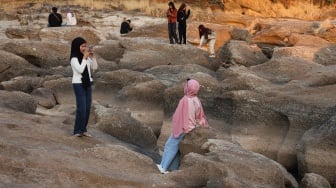 Warga berfoto di area aliran Sungai Jeneberang yang mengering di Kabupaten Gowa, Sulawesi Selatan, Minggu (13/9/2026). [ANTARA FOTO/Arnas Padda/hma]
