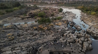 Foto udara warga menikmati suasana di area aliran Sungai Jeneberang yang mengering di Kabupaten Gowa, Sulawesi Selatan, Minggu (13/9/2026). [ANTARA FOTO/Arnas Padda/hma]