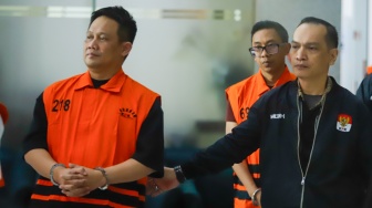 Mantan Bupati Kebumen Arif Sugiyanto (kiri) berjalan menuju mobil tahanan usai menjalani pemeriksaan di Gedung Merah Putih KPK, Jakarta, Selasa (15/9/2026). [Suara.com/Alfian Winanto]