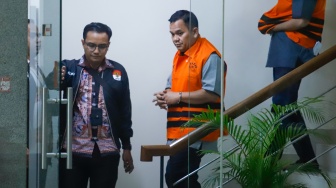Kepala BPN Kabupaten Bogor Sontang Coin Manurung (tengah) berjalan menuju mobil tahanan usai menjalani pemeriksaan di Gedung Merah Putih KPK, Jakarta, Selasa (15/9/2026). [Suara.com/Alfian Winanto]