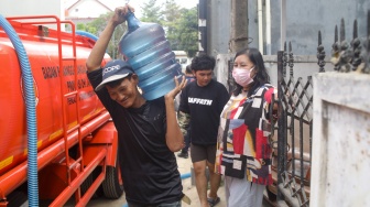 Warga membawa wadah berisi air bersih di Lenteng Agung, Jakarta, Jumat (18/9/2026). [Suara.com/Alfian Winanto]