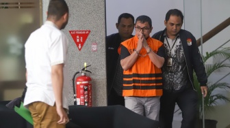 Bupati Bolaang Mongondow Utara, Sirajudin Lasena (tengah) mengenakan rompi tahanan berjalan menuju mobil tahanan usai menjalani pemeriksaan di Gedung Merah Putih KPK, Jakarta, Selasa (22/9/2026). [Suara.com/Alfian Winanto]