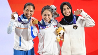Lifter putri Indonesia Luluk Diana Tri Wijayana (kanan), lifter Korea Utara Ri Song Gum (tengah), dan lifter India Saikhom Mirabai (kiri) memperlihatkan medali yang diperoleh seusai bertanding pada final kelas 49 kilogram angkat besi putri Asian Games Aichi-Nagoya 2026 di Nagoya City Trade and Industry Center, Nagoya, Aichi, Jepang, Rabu (23/9/2026). [ANTARA FOTO/Fauzan/kye]