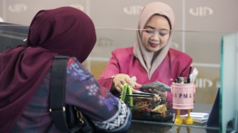Petugas melayani penukaran uang asing di Jakarta, Selasa (29/9/2026). [Suara.com/Alfian Winanto]