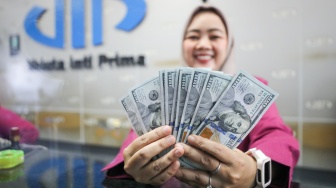 Petugas salah satu tempat penukaran mata uang asing menunjukkan mata uang dollar AS di Jakarta, Selasa (29/9/2026). [Suara.com/Alfian Winanto]
