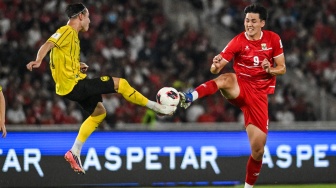 Pesepak bola Timnas Indonesia Mitchell Baker (kanan) berebut bola dengan pesepak bola Timnas Malaysia Dion Cools (kiri) pada pertandingan penyisihan Grup A FIFA ASEAN Cup 2026 di Stadion Utama Gelora Bung Karno, Senayan, Jakarta, Senin (28/9/2026).  [ANTARA FOTO/Rivan Awal Lingga/app/kye]