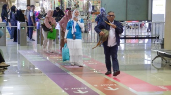 Pengguna transportasi umum berjalan mengikuti penunjuk arah (wayfinding) di area Terminal Blok M, Jakarta Selatan, Rabu (30/9/2026). [Suara.com/Alfian Winanto]