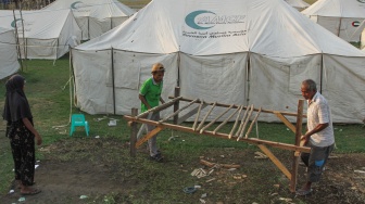 Sejumlah warga mengangkat alas tempat tidur untuk diletakkan di dalam tenda pengungsian, di Tendakinde, Kabupaten Nagekeo, Nusa Tenggara Timur, Selasa (29/9/2026). [ANTARA FOTO/Mega Tokan/app/rwa]