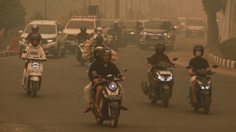Sejumlah pengendara motor melintasi Bundaran Burung saat kabut asap di Palangka Raya, Kalimantan Tengah, Selasa (29/9/2026). [ANTARA FOTO/Auliya Rahman/rwa]