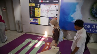 Pengguna transportasi umum berjalan mengikuti penunjuk arah (wayfinding) di area Terminal Blok M, Jakarta Selatan, Rabu (30/9/2026). [Suara.com/Alfian Winanto]