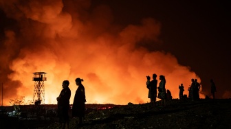 Sejumlah warga menyaksikan api yang membakar tumpukan sampah di Tempat Pembuangan Akhir (TPA) Jatibarang Zona 1, Semarang, Jawa Tengah, Rabu (30/9/2026). [ANTARA FOTO/Aprillio Akbar/YU]