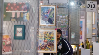 Pengunjung mengamati berbagai karya seni yang ditampilkan dalam Jakarta Illustration and Creative Arts Fair (JICAF) 2026 di Agora Mall, Thamrin, Jakarta, Kamis (1/10/2026). [Suara.com/Alfian Winanto]