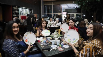 Para tamu menunjukan hasil melukis batik di atas piring dalam acara Batik Reimagined di Manhattan Hotel, Jakarta, Jumat (2/10/2026). [Suara.com/Alfian Winanto]