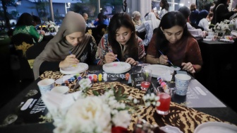 Para tamu melukis batik di atas piring dalam acara Batik Reimagined di Manhattan Hotel, Jakarta, Jumat (2/10/2026). [Suara.com/Alfian Winanto]
