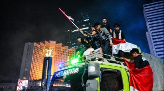 Warga merayakan kemenangan Timnas Indonesia yang menjuarai FIFA ASEAN Cup 2026, di Bundaran HI, Jakarta, Senin (5/10/2026). [ANTARA FOTO/Fathul Habib Sholeh/sgd]
