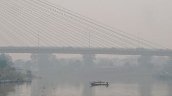 Sejumlah kendaraan melintas di atas jembatan Siak III yang dipenuhi kabut asap di Pekanbaru, Riau, Rabu (7/10/2026). [ANTARA FOTO/Rony Muharrman/YU]