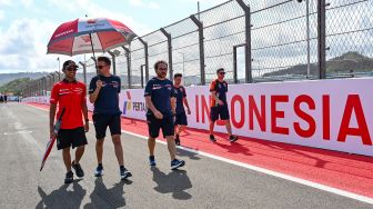 Pembalap Honda Team Asia Veda Pratama (kiri) berjalan keliling sirkuit bersama rekan timnya saat mengikuti sesi pengenalan lintasan (riders track familiarisation) jelang balapan MotoGP di Sirkuit Internasional Pertamina Mandalika, KEK Mandalika, Kuta, Praya, Lombok Tengah, NTB, Kamis (8/10/2026). [ANTARA FOTO/Ahmad Subaidi/YU]
