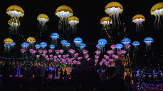 Pengunjung swafoto saat festival lampu Lumiland atau wisata cahaya di Taman Wiradadaha, Kota Tasikmalaya, Jawa Barat, Jumat (9/10/2026). [ANTARA FOTO/Adeng Bustomi/nym]
