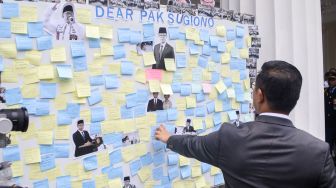 Pejabat lama Menteri Luar Negeri Sugiono melihat ucapan perpisahan para pegawai Kementerian Luar Negeri dalam acara pisah sambut pejabat baru dan lama di Gedung Pancasila, Kementerian Luar Negeri, Jakarta, Senin (12/10/2026). [Suara.com/Alfian Winanto]