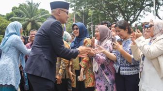 Menteri Luar Negeri Arrmanatha Nasir bersama Istri Nur Indah Sari menyapa pegawai Kementerian Luar Negeri dalam acara pisah sambut pejabat baru dan lama di Gedung Pancasila, Kementerian Luar Negeri, Jakarta, Senin (12/10/2026). [Suara.com/Alfian Winanto]